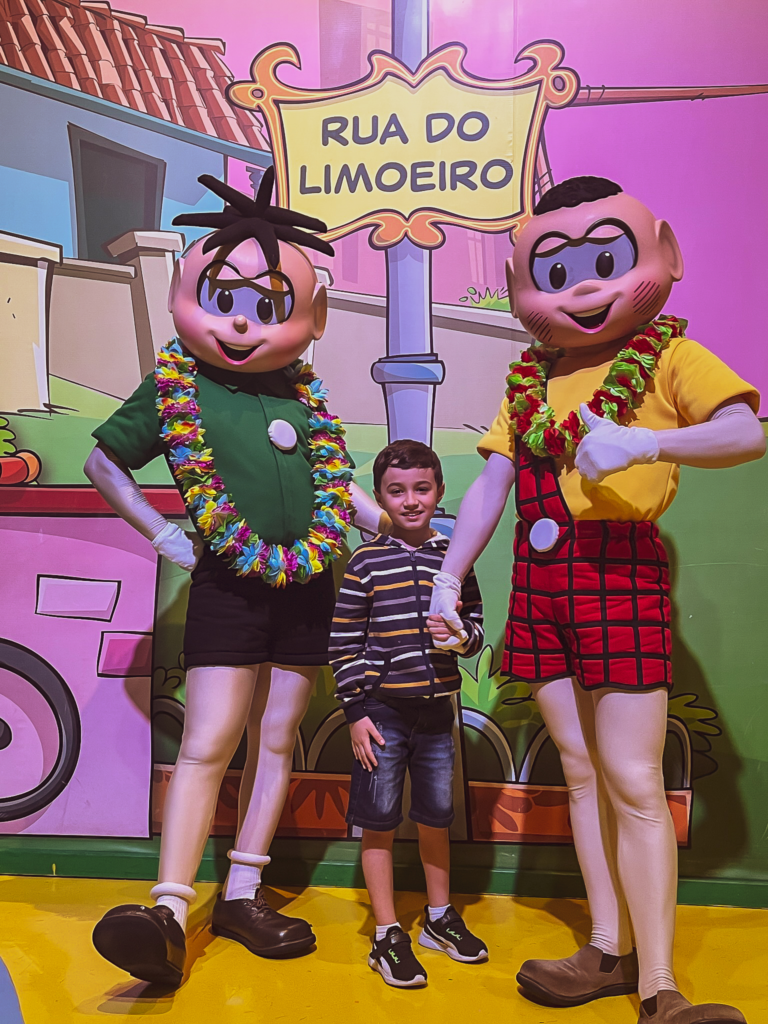 Caio, e os personagens Cascão e Cebolinha no Parque da Mônica