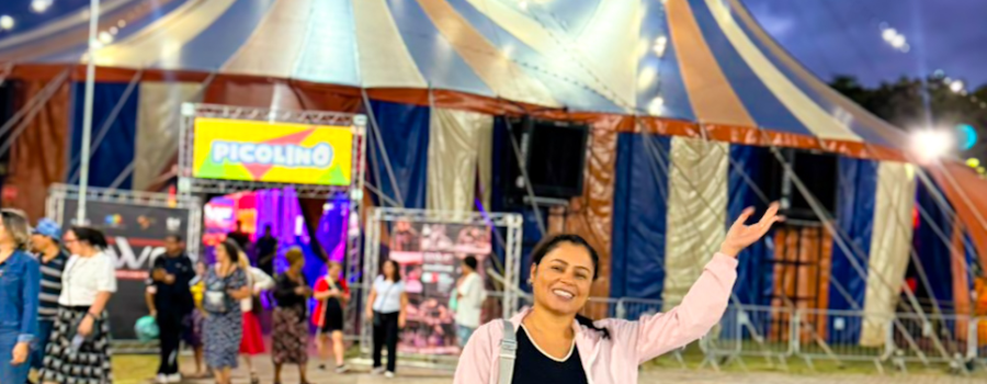 Carla com imagem de circo ao fundo